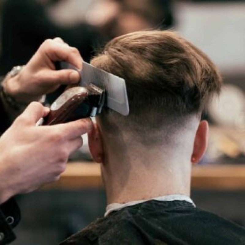 Busy day at English style barber shop with clients and barbers.