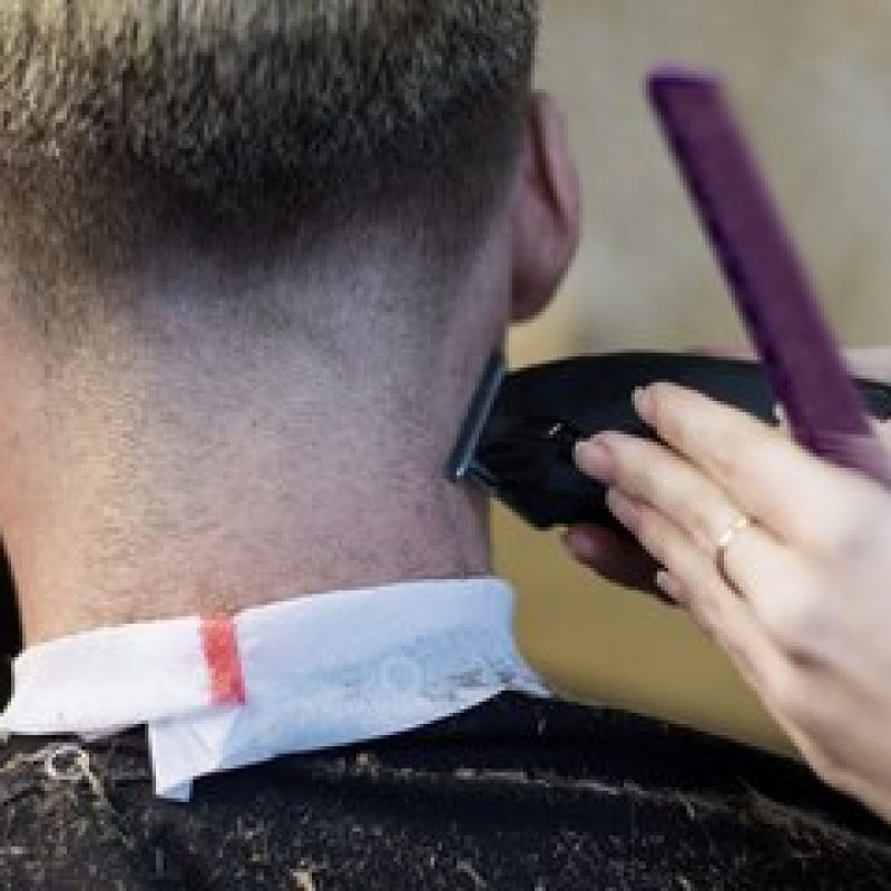 salon-coiffure-gros-plan-mains-femme-faisant-coupe-cheveux-homme-machine_126362-570